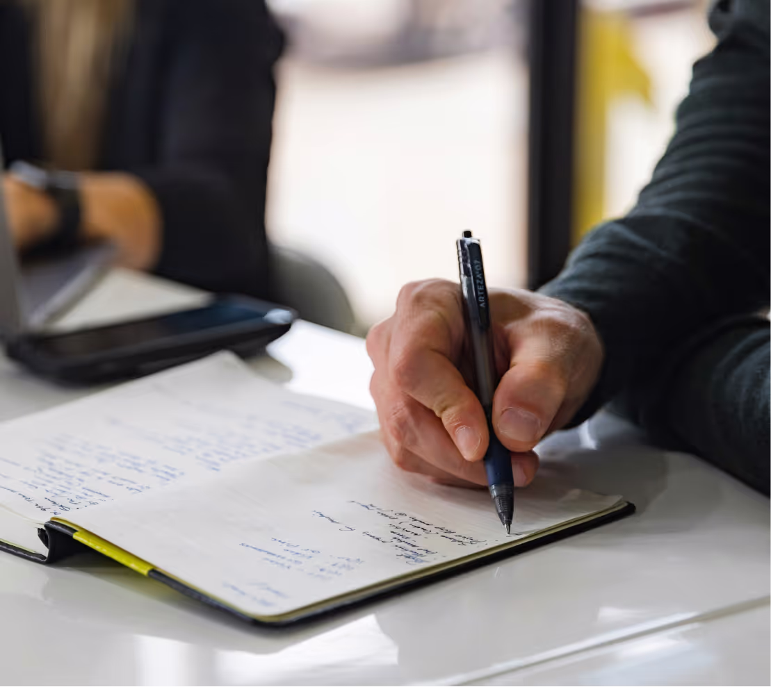 A person writing something into a notebook